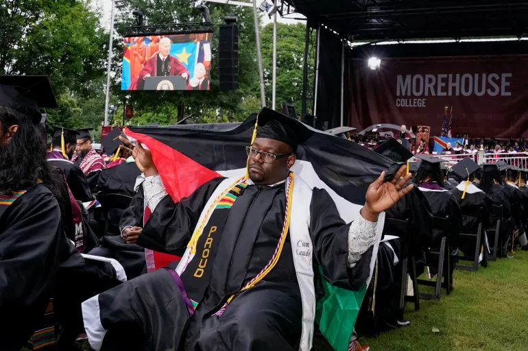 Ένας απόφοιτος του Morehouse College κρατάει μια παλαιστινιακή σημαία ενώ ο Μπάιντεν μιλάει στις 19 Μαΐου [Elizabeth Frantz/Reuters]