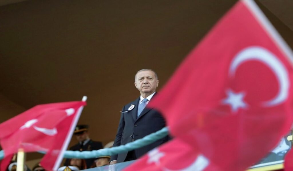 Τουρκική στρατηγική βάθους από τη Σομαλία έως την Ανατολική Μεσόγειο – Τι σημαίνει για Ελλάδα και Κύπρο Άνδρας με κοστούμι πίσω από τουρκικές σημαίες