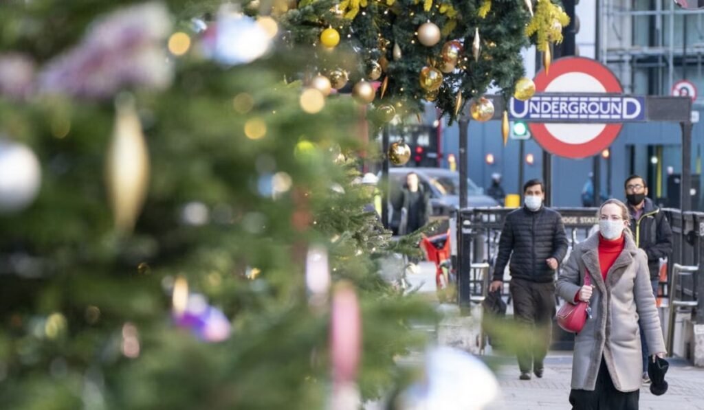 Υπεργρίπη στη Βρετανία: Απειλείται η Ευρώπη με νέο υγειονομικό κύμα Άνθρωποι με μάσκες κοντά σε χριστουγεννιάτικο δέντρο Λονδίνου